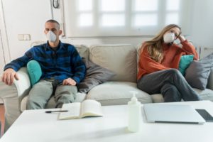 Hombre y mujer en un sillon con mascarilla