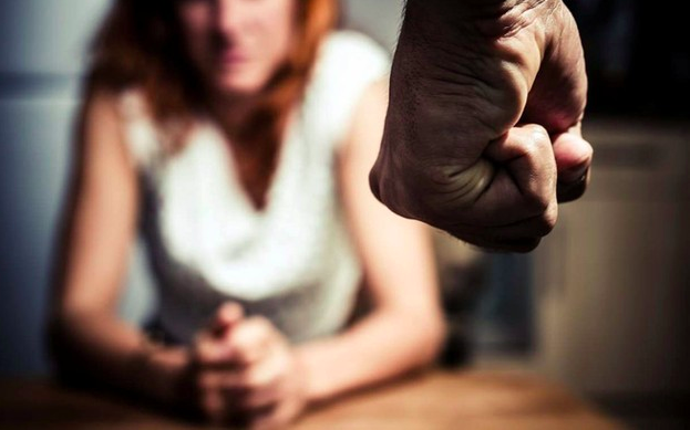 Puño de un hombre enojado y una mujer asustada