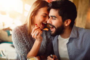 Mujer dando un cucharada de comida a su esposo
