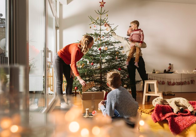 Familia ayudando a arreglar un arbol de navidad
