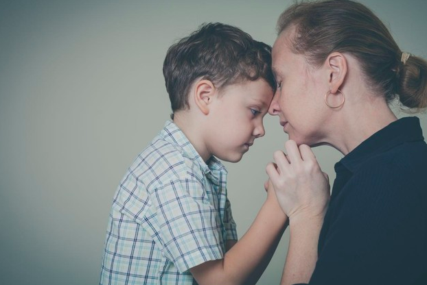 niño tomado de las manos por su madre