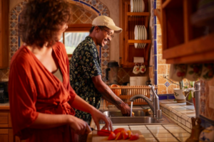 Esposos en la cocina cocinando y lavando los platos