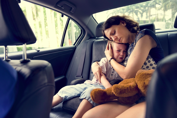 Niño llorando en un carro y su mamá consolandolo