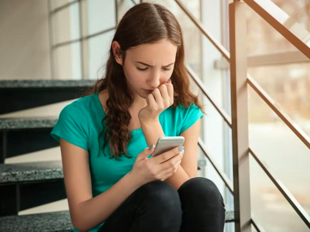 mujer preocupada viendo un celular
