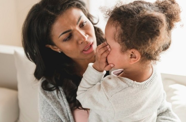 madre viendo a su hija que se tapa la cara