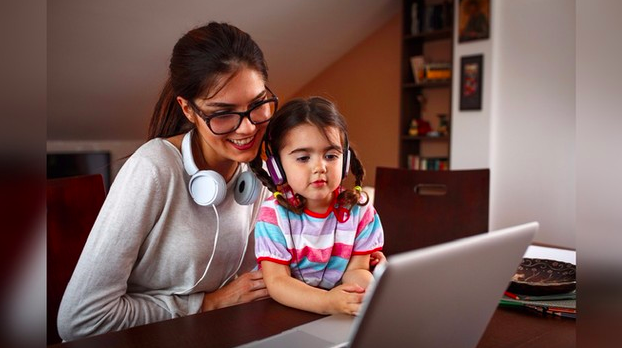 niña usando una laptop junto a su madre
