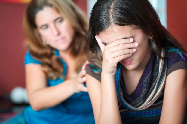 Madre apoyando su mano en su hija preocupada