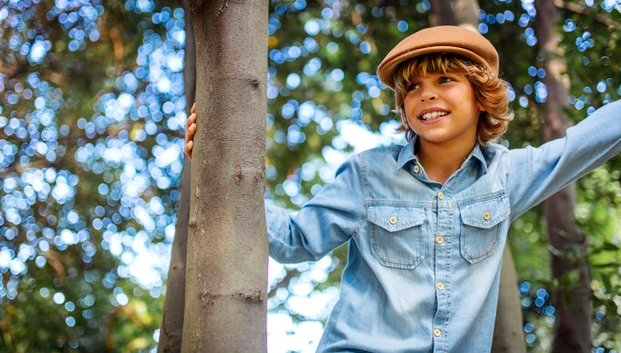 niño jugando en y subido en un arbol