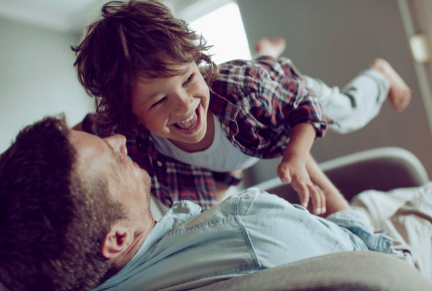 Papá jugando con su hija en un sofa
