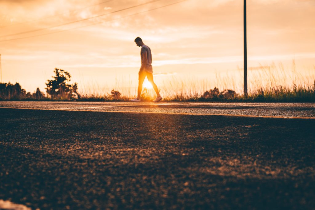 hombre caminando solo por un camino