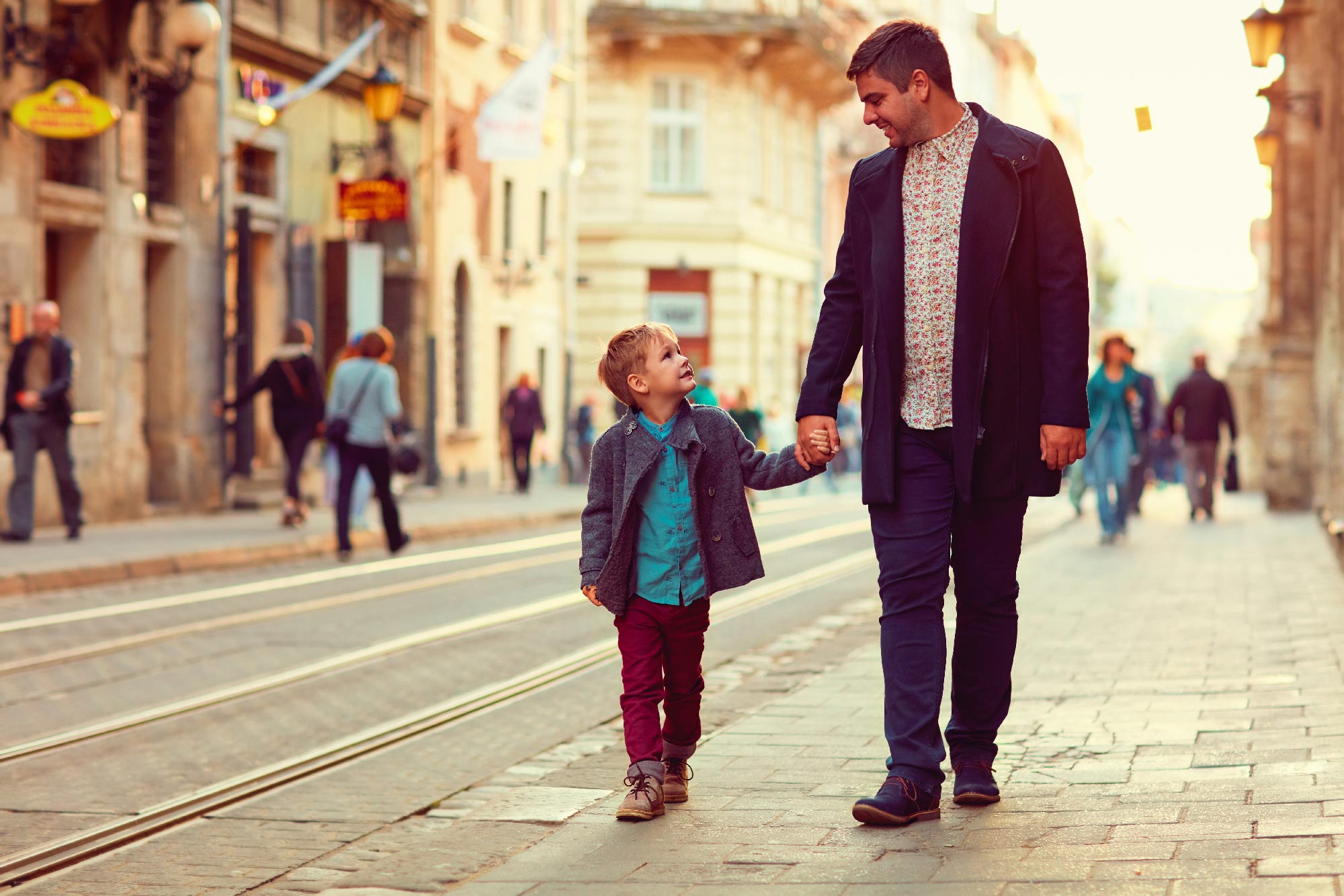 Hijo y padre caminando por un acera