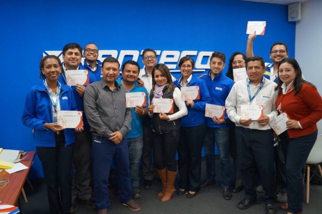 Hombres y mujeres recibiendo un titulo en un taller