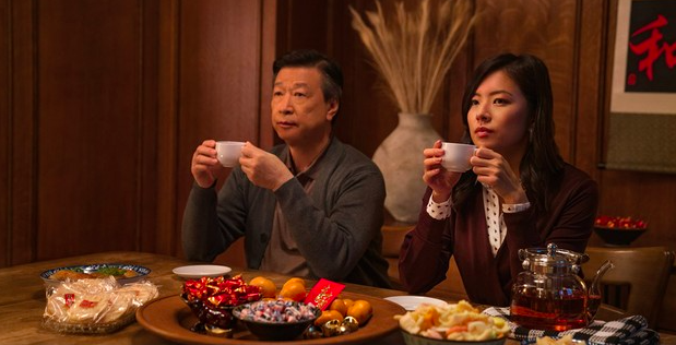 Hombre mayor y mujer joven con rasgos asiaticos tomando té