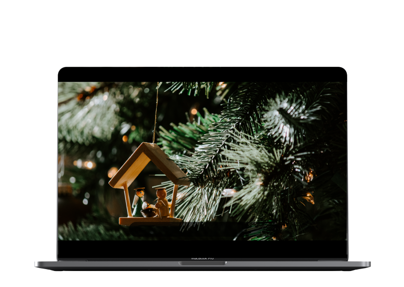 Laptop con imagen de un adorno de pesebre en un árbol de navidad