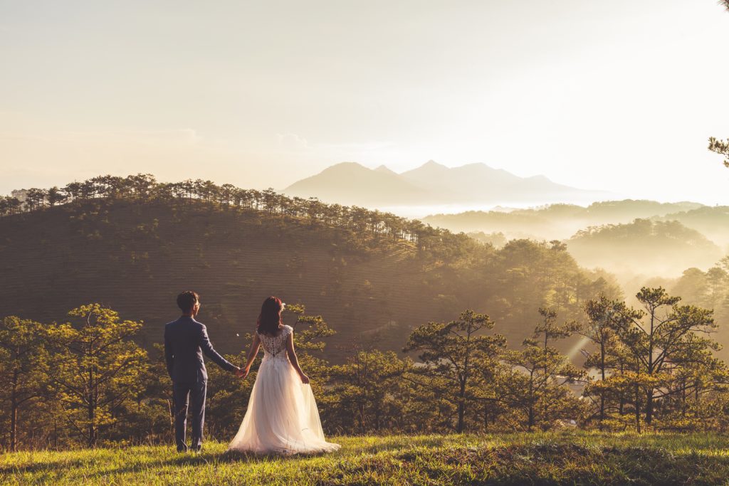 Recien casados en un monte viendo las montañas