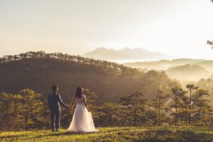 Recien casados en un monte viendo las montañas
